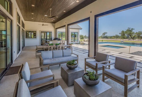 A stylish patio with outdoor furniture and a swimming pool, showcasing exterior home remodeling trends for expanded outdoor living spaces.