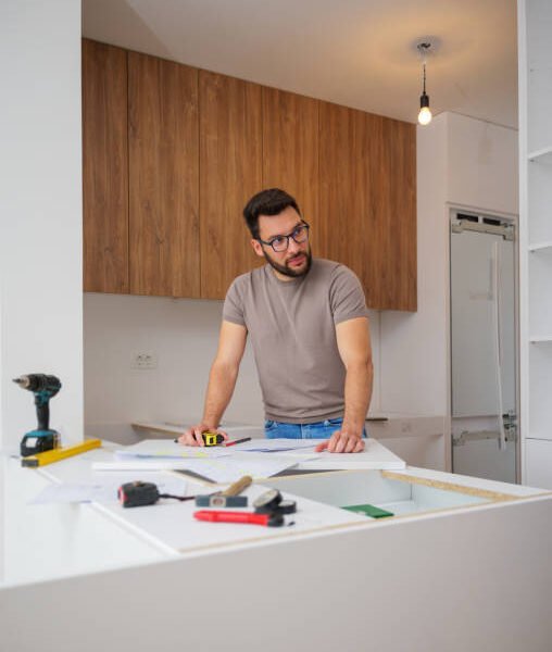 San Jose kitchen remodel contractor reviewing renovation blueprints in a modern kitchen setting.